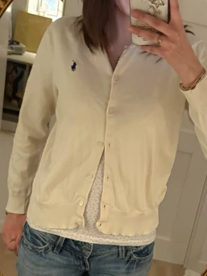 Gullig tunn ljusgul kofta ifrån Ralph Lauren - Söt ljusgul vintage kofta ifrån Ralph Lauren. Den är i storlek L men är mindre i storlek så passar mig som oftast är Xs/S. Ena knappen har en skada som syns på 4e bilden men den går att knäppa ändå.