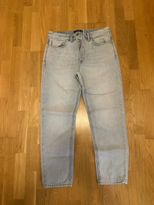 Ljusblå raka jeans från Neuw - Säljer ett par ljusblå jeans från Neuw med klassisk femficksmodell och raka ben. Jeansen har knappgylf och bälteshällor, tillverkade i mjuk bomullsdenim. Perfekta för en avslappnad och trendig look.