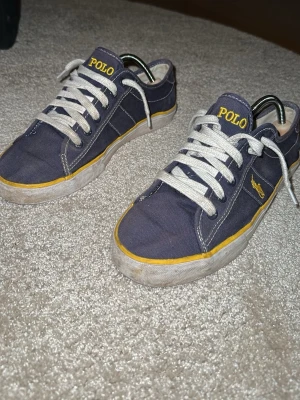  Ralph Lauren skor  -  Ett par Ralph Lauren skor jag köpte här på plick  för ett tag sen. De är gula och marinblå. Nya snören. Säljer för de är för små