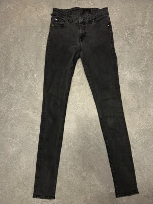 Svarta skinny jeans med hög midja från tiger of Sweden  - Säljer ett par svarta skinny jeans med hög midja. Jätte skinny ett bält hål är trasigt och ett lagat