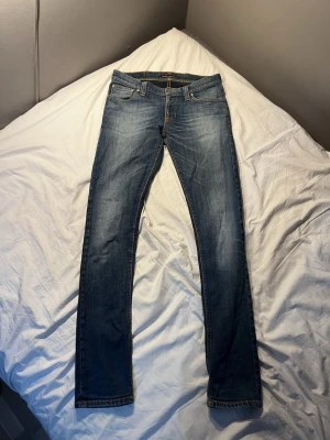 Blå nudie jeans storlek 30/34 - Säljer ett par klassiska blå nudie jeans med straight fit/slim fit. 