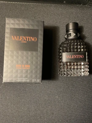 Valentino Uomo Born In Roma parfym - Valentino Uomo Born In Roma Coral Fantasy är en lyxig herrparfym i en stilren, mörk glasflaska med nitar och svart kork. Doften kommer i en elegant svart kartong med orange detaljer. Flaskan rymmer 50 ml eau de toilette. Finns cirka 70% procent kvar av parfymen pris går att diskutera