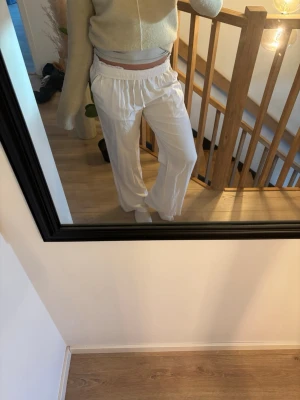Vita linnebyxor med resårmidja - Säljer ett par vita linnebyxor med resår och snörning i midjan. Från lager 157 i storlek XS!De har en ficka bak❣️jag har vikt ner kanten på bilden!