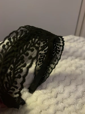 Brett svart spetsdiadem - Snyggt och brett diadem i svart spets med vackert mönster. Spetsen ger en elegant touch och passar till många olika stilar. Har aldrig kommit till användning och är från Shein 