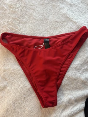 Röd bikiniunderdel från NA-KD - Röd bikiniunderdel från NA-KD. Aldrig använd. I storlek M.