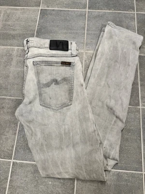 Nudie tight long John  - Sparsamt använda grå jeans från Nudie. Strl w28 l32. Nypris 1599kr.