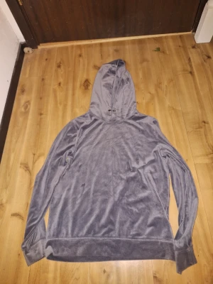 Grå velour hoodie från Esmara - Mjuk och skön grå hoodie i ett mjukt tyg från Esmara. Tröjan har huva och långa ärmar. Perfekt för en avslappnad och chill stil. Materialet är glansigt och känns lyxigt mot huden.