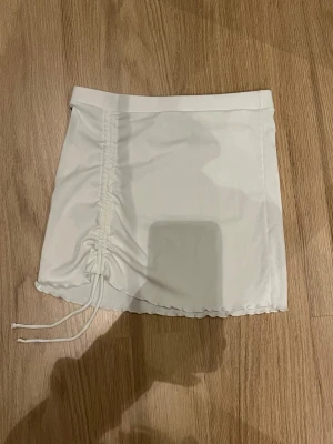 Vit kortkjol - Med snöre/knyte över höften! Ingen storlek finns men passar mig som är M. Pris är diskuterbart✨