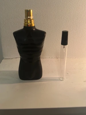 Jean Paul Gaultier Le Male parfym - Säljer en Jean Paul Gaultier Le Male parfym i svart, matt flaska formad som en manlig torso med guldfärgad spraykork. Flaskan har en unik och stilren design. Medföljer även ett litet genomskinligt provrör med svart lock.