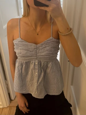 Randig linnetopp med smala axelband - Jättefin topp från primark. Den har vita och ljusblå ränder. Storlek 36🩷