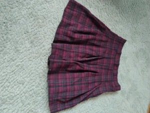 Rutig vinröd kortkjol från Zara - Superfin rutig kortkjol från Zara i vinrött och svart. Kjolen har klassiskt rutmönster och är lätt utställd med veck för extra volym. Perfekt för dig som gillar en preppy och trendig stil. Helt oanvänd, så i perfekt skick.