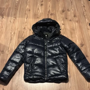 Mörkblå pufferjacka från G-Star RAW - Säljer nu min mörkblå pufferjacka från G-star då den var för stor när jag beställt den. Jackan är helt oanvänd så i skicket är den som ny. Det finns två fickor, dock bara med knapp. Luvan är avtagbar även den med knapp