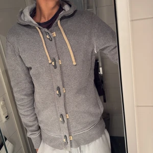 Grå hoodie med snygga knappar  - Vädldigt snygg hoodie med coola knappar.😁 perfekt för att få en mysig och trevligt känsla under vinter.✌️