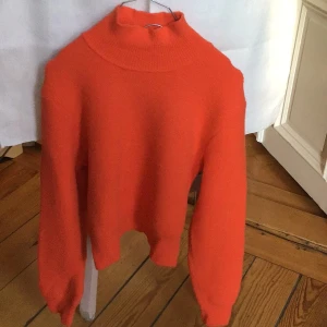Orange polotröja från Zara, M - Säljer en snygg orange polotröja från Zara i storlek M. Tröjan har en hög krage och är långärmad med loose passform. Materialet är en mix av nylon, viskos och polyester som känns mjukt och skönt mot huden. Perfekt för dig som gillar färgstarka plagg.