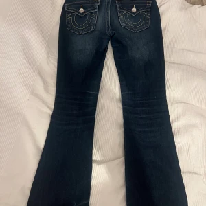 True Religion bootcut jeans lowwaist  - Snygga mörkblå jeans från True Religion, modell Becca Mid Rise Bootcut. Stl 26, se bild, då det varit för långa så har jag gått upp de ( se bild) därav pris 