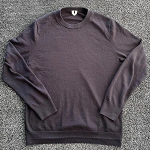 ARKET Stickad tröja - En enkel svart stickad tröja i bomull med rund hals och långa ärmar. Tröjan har ribbade muddar vid ärmslut och nederkant, vilket ger en clean och klassisk look m. Skick 8/10 har ett hål men annars bra skick, storlek M. Pris går att diskutera✅