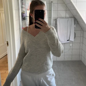 Ljusgrå stickad v-ringad tröja - Stickad, ribbat material och v-ringad hals. Superfin och går att styla på olika sätt. Samma skurning i bak. Kommer tyvärr inte till användning längre🩶strl 34/36