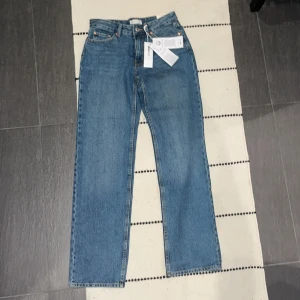 Blå low straight jeans från Gina Tricot - Snygga blå jeans från Gina Tricot i modellen 'perfect jeans' med låg midja och raka ben. Klassisk femficksdesign, dragkedja och knapp framtill. Jeansen är tillverkade i bomull och har en tidlös blå tvätt som passar till allt. Jättefina jeans men dom är för stora för mig 