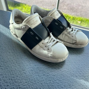 Valentino Garavani Open sneakers vit/blå - Säljer nu vidare mina Valentino skor. Köpte förra sommaren men nu dags att sälja vidare de. Finns tydliga tecken på användning vilket syns på bilderna. Storleken är 43. Endast skor medföljer vid köp. Hör av dig vid eventuella frågor. 