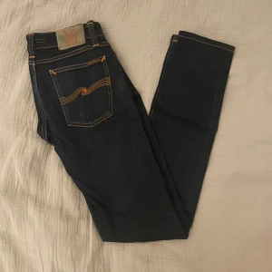 Mörkblå nudie jeans - Snygga slim jeans från Nudie i klassisk mörkblå färg . Riktigt bra passform och tidlös stil som funkar till allt – både vardag och fest.  📏 Storlek: W29 L32 ✨ Skick: Mycket bra skick, sparsamt använda. 🧵 Material: Bomull med stretch för bekväm passform.                                                                        ✅ Pris kan diskuteras