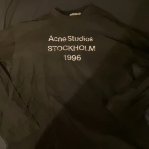 Svart långärmad tröja Acne Studios M - Svart långärmad tröja från Acne Studios med tryck 'Acne Studios STOCKHOLM 1996' i vitt på bröstet. Tröjan är i 100% bomull och har en klassisk rund hals. Perfekt för dig som gillar stilrena och ikoniska plagg med streetkänsla. Lite dåliga bilder men ja, går att sänka priset via snabbaffär 