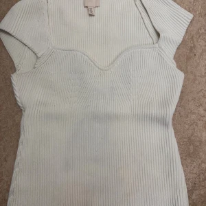 Vit  topp - Säljer en vit ribbad topp från H&M, väldigt snyggt och tjockt material, i storlek S men den är stretchig så funkar även för en M. Endast använd en gång dåd en är stor på mig.  