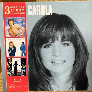 Carola - 3 Original Album Classics (Främling, Steg för steg, My Tribute) - Samlarbox med tre klassiska Carola-album: Främling, Steg för steg och My Tribute. Innehåller 3 CD-skivor med många av Carolas mest älskade låtar. Fodralet är i fint skick med mindre spår av hantering. Perfekt för samlare och fans av svensk pop.