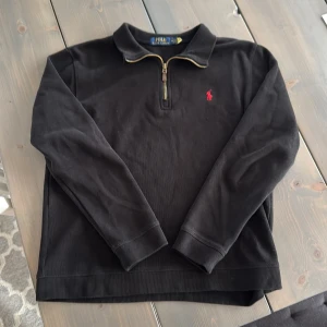 Half Zip tröja från Ralph Lauren - Svart 1/4 zip tröja från Ralph Lauren med klassisk röd  logga. Riktigt härlig kvalitet och jag är ca 188cm lång på tredje bilden. Pris kan diskuteras ✅