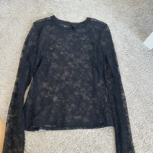 Svart spetsblus - Snygg spetstopp från Lindex. Den har små hål men det syns inte så mycket när man har på sig den. 