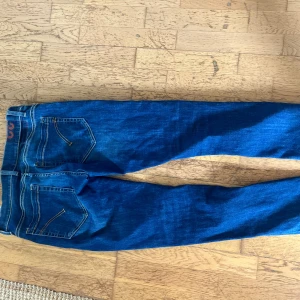 Dondup mörkblå jeans - Snygga blå Dondup jeans med klassisk femficksdesign och smal passform. Jeansen har kontrastsömmar och en mörk tvätt som ger en fräsch look. Perfekt för dig som gillar stilrena och tidlösa jeans med lite stretch i materialet.