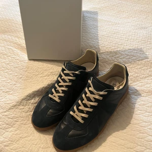Maison Margiela blå sneakers mocka/läder - Säljer nu ett par riktigt schyssta maison margielas. Skorna är i topp skick och är bara använda ett fåtal gånger. Priset är inte hugget i sten det går att diskutera. Finns kvitto som jag kan skicka. Skorna är i storlek 43 men passar som en 42. Hör gärna av er om ni har några funderingar😀