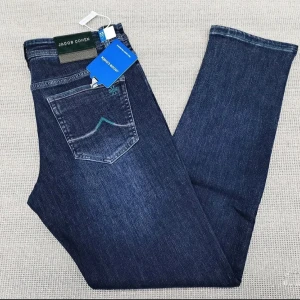 Jacob Cohen jeans  - Snygga blå jeansbyxor från Jacob Cohen med klassisk femficksdesign och diskreta kontrastsömmar på bakfickan. Byxorna har normal passform och är tillverkade i mjukt jeanstyg som ger en stilren look. Perfekta för dig som gillar stilrena och tidlösa jeans. 1;1