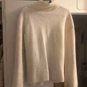 Vit polotröja från GANT - Säljer en supermjuk och ribbstickad vit polotröja från GANT. Tröjan har lång ärm, hög polokrage och en loose fit som ger en chill vibe. Perfekt för lager på lager under höst och vinter. Klassisk och enkel design som funkar till allt.