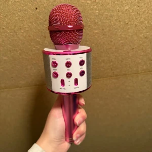 Trådlös Karaoke Mikrofon Bluetooth Rosa - Snygg rosa trådlös karaoke-mikrofon med Bluetooth, AUX, USB och TF-kort. Flera knappar för volym, remix och inspelning. Perfekt för fester och sång. Ser ut att vara i gott skick utan synligt slitage eller defekter. Och funkar perfekt 