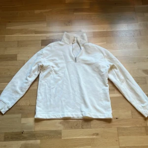 Vit half zip sweatshirt - Vit sweatshirt med half zip och hög krage från arket. Tröjan har lång ärm och är tillverkad i mjukt material, perfekt för lager-på-lager. Enkel och clean design som funkar till allt.