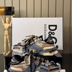 Dolce & Gabbana chunky sneakers - Säljer ett par riktigt feta chunky sneakers från Dolce & Gabbana med coola detaljer och flera lager i beige, grått och svart. Skorna har snörning, platt sula och massor av grafiska inslag och loggor. Perfekt för dig som vill sticka ut med en unik streetstyle.Damer, alla nummer tillgängliga, vänligen fråga efter nummer