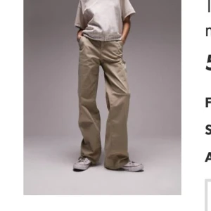 Beiga wide chinos från Topshop - Snygga beiga chinos från Topshop med breda medelhög midja och raka ben. Byxorna har hällor för bälte, sidfickor. Perfekta för en avslappnad och trendig look.