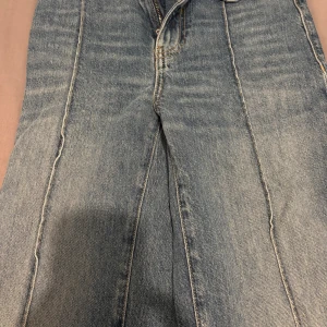 Blå jeans från MNG med raka ben - Säljer ett par klassiska blå jeans från MNG med raka ben och hög midja. Jeansen har tydliga sömmar, fem fickor och en snygg vintage tvätt. Materialet är robust denim och passformen är normal. Perfekt för dig som gillar utsvängda byxor 