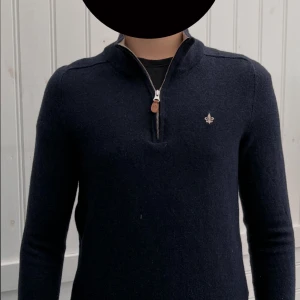 Mörkblå merinoullströja Morris XS - ‼️tröjan sitter som XS‼️               Snygg mörkblå    stickad tröja från Morris i 100% merinoull. Tröjan har half zip med läderdetalj och en liten broderad logga på bröstet. Klassisk passform och långärmad, perfekt för dig som gillar stilrena och bekväma plagg.