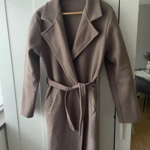 Kappa - Säljer en jättefin beige kappa från missäy! Kappan är i väldigt bra skick och knappt använd💕 Jag är 1,73 och den går lite längre ner än mina knäveck