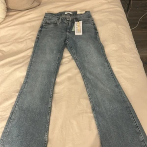 Gina tricot boot cut jeans - Säljer ett par gina tricot jeans i ljusblå tvätt med klassisk bootcut passform. Jeansen har fem fickor, knapp och dragkedja . Perfekta för dig som gillar retrovibe och snygg siluett. Dem är oanvänd också och helt nya med ettiken på 