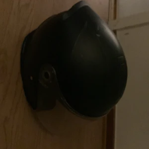  Haft den i ett år  - Bilden visar en hjälm med visir, troligen för skydd vid arbete eller sport. Ingen elektronik syns och inga märkningar eller modeller kan identifieras. Produkten verkar vara i använt skick med vissa repor på visiret.