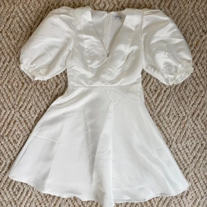 Studentklänning  - Säljer min så fina studentklänning. Den har en lätt glansig finish och är av satinliknande material. Klänningen har puffiga korta ärmar, är tajt i midjan och utsvängd över höfterna, vilket skapar en väldigt fin siluett. Den är använd endast 1 gång, har inga fläckar eller andra defekter - så i toppenskick! Bara att skriva om du har några funderingar 🤍🤍