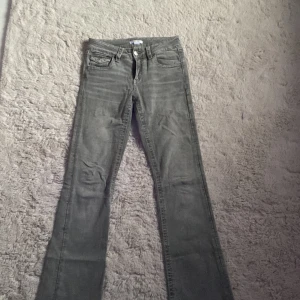 Grå bootcut jeans från Gina Tricot - Snygga grå jeans från Gina Tricot dom är låg midjade och bootcut. NY UTAN PRISLAPP!