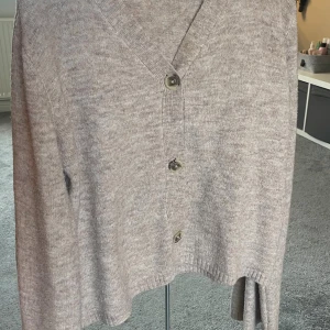 Beige stickad kofta med knappar - Säljer denna mysiga beige stickade koftan med v-ringning och tre knappar framtill. I storlek xs frpn lager 157. Använd npgra gånger för länge sen, så jag säljer då den inte kommer till användning mer!