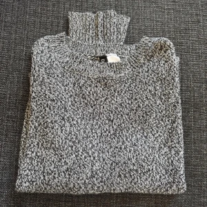 Gråmelerad stickad polotröja - Säljer en gråmelerad stickad polotröja från DIVIDED. Tröjan har en hög krage, lång ärm och är ribbstickad vid hals och ärmslut. Perfekt för lager-på-lager och chill höst- eller vinterstil.