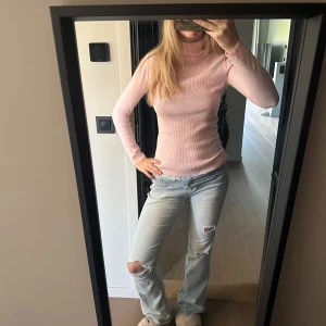 Ljusrosa polotopp från HV Society - Säljer en ljusrosa ribbad polotopp från HV Society i storlek S. Toppen har lång ärm, tight passform och är tillverkad i ett mjukt, stretchigt material. Perfekt att styla med jeans eller kjol för en snygg look.