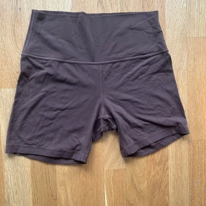  Lululemon shorts  - Ett par bruna tränings shorts från lululemon. Saknar lapp ungefär storlek 12 i deras storlekar motsvarar ungefär L. Kanappt använda 