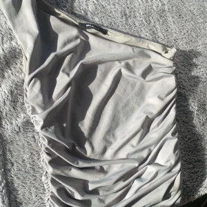 Assymetrisk topp - Superfin topp med en ärm, räfflade sidor. Jätteskönt material satin. Storlek xs💗💕