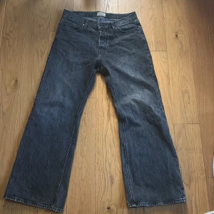 Jack & Jones Flared Toby jeans 32/32 - Säljer ett par mörkblå flared jeans från Jack & Jones, modell Flared Toby. Klassisk femficksdesign, raka ben med utsvängd passform och snygg tvättad denimlook. Perfekta för dig som gillar retrovibbar och vill sticka ut lite extra.
